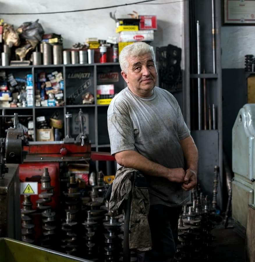 A mechanic standing proudly in his workshop